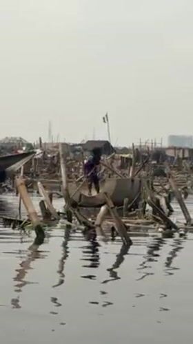 Person poles makeshift concrete boat through Lagos waterway