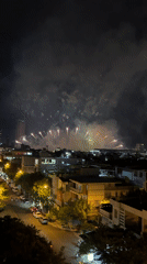 Fireworks over Đà Nẵng, seen from street-level rooftops