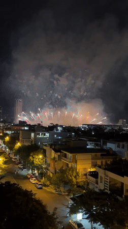 Fireworks over Đà Nẵng, seen from street-level rooftops