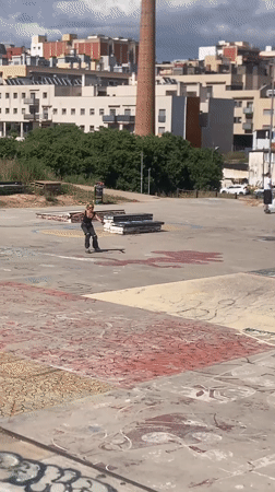 Pink-haired roller skater practices tricks at Badalona skatepark