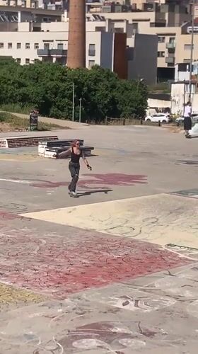 Pink-haired roller skater practices tricks at Badalona skatepark