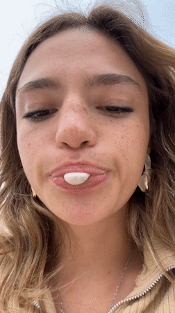 Woman blows bubblegum bubbles in close-up footage, Puebla