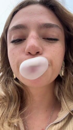 Woman blows bubblegum bubbles in close-up footage, Puebla