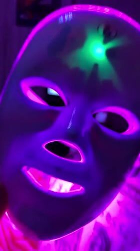 LED face mask session in a Ufa bedroom, late evening