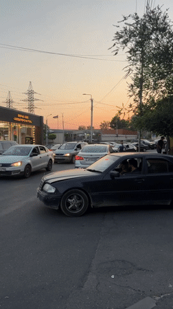 Yerevan street at dusk, pedestrian traffic and parked cars