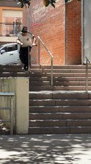 Scooter rider descends concrete stairs in Barcelona
