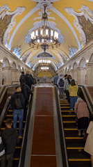 Morning rush hour crowds navigate ornate Moscow metro stations