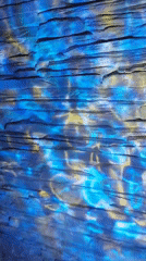 Blue-yellow light display creates water effects on stone surfaces