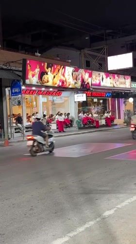 Night street scene with massage parlor signs in Pattaya