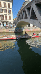 Boats navigate Milan canal on sunny morning