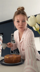 Woman decorates homemade cake in pajamas Saturday afternoon