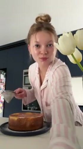 Woman decorates homemade cake in pajamas Saturday afternoon