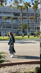 Two people walk through sunny park in Sirius, Russia