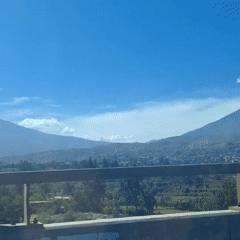 Vehicle crosses bridge overlooking Arequipa beneath snow-capped mountain