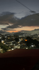 Nighttime scenes in Caracas feature cityscape view and cat