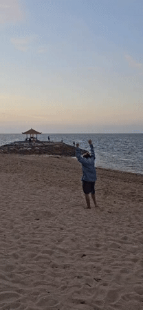 Evening beach scenes document mixed activities, cleanup in Denpasar