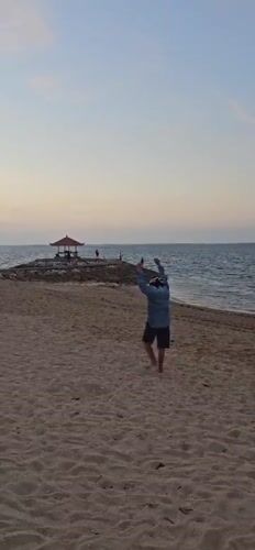 Evening beach scenes document mixed activities, cleanup in Denpasar