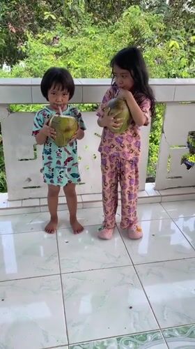 Children enjoy fresh coconuts in Kiblawan, Philippines morning scenes