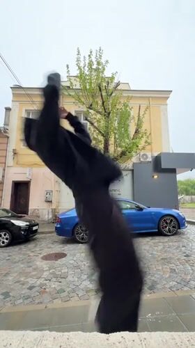 Man in black performs activity on wet Shumen street