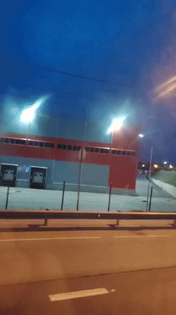 Evening road trip through Radumlya past lit commercial strips
