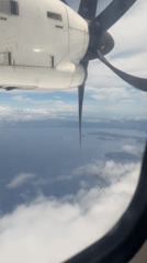 Aircraft passenger films propeller view over Philippine waters