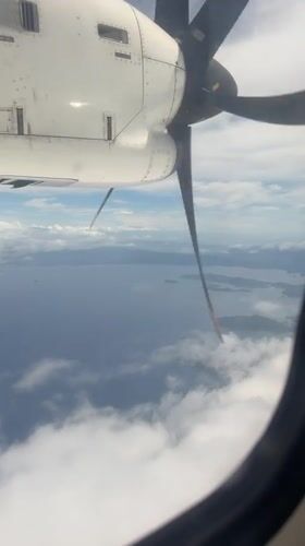 Aircraft passenger films propeller view over Philippine waters