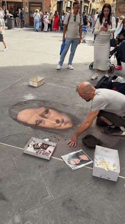 Street artist draws chalk portraits in Florence public square