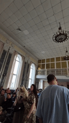 Busy afternoon at Izhevsk train station, travelers waiting with luggage.