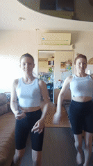 Two women dance in sync wearing matching outfits