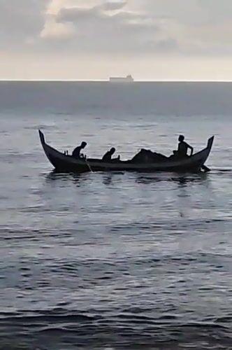 Sunrise on the Lhokseumawe coast, fishing boat and quiet shoreline
