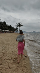 Woman runs barefoot on overcast beach in Vietnam