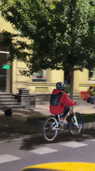 Cyclist in red jacket rides white bike through Tbilisi