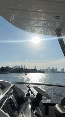 Boater films Miami skyline sunset from yacht cockpit