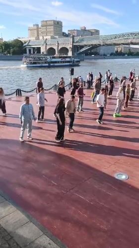 Group dance on a waterside wooden platform in Moscow