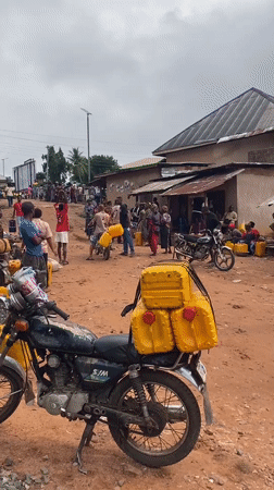 Villagers queue with jerry cans for water collection