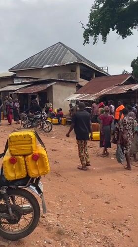 Villagers queue with jerry cans for water collection