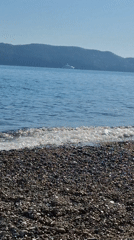Quiet beach day observed in Budva with paragliding activity
