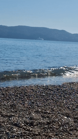 Quiet beach day observed in Budva with paragliding activity