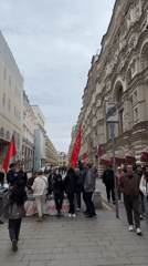 Red flag demonstration blocks city sidewalk pedestrian traffic