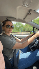Woman drives through Virpazar, Montenegro on sunny day