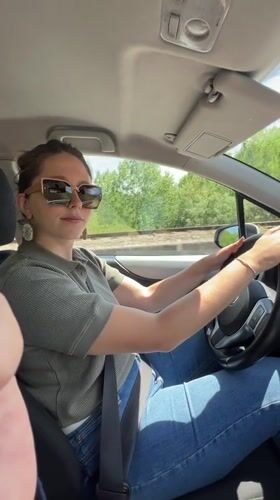 Woman drives through Virpazar, Montenegro on sunny day