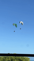 Two paragliders spotted in clear skies from ground observer