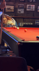 Woman plays pool at Tbilisi bar during afternoon