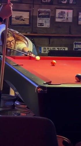 Woman plays pool at Tbilisi bar during afternoon
