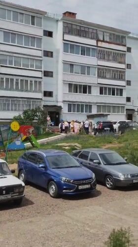 Group outside apartment block, then aboard transit in Noviy