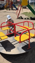 Toddler plays on merry-go-round in Omsk playground