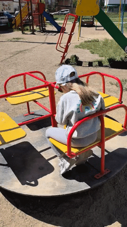 Toddler plays on merry-go-round in Omsk playground