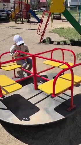 Toddler plays on merry-go-round in Omsk playground