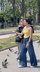 Visitors feed parrots near Barcelona's Arc de Triomf