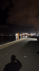 Nighttime harbor walkway documented in Lisbon with industrial lighting